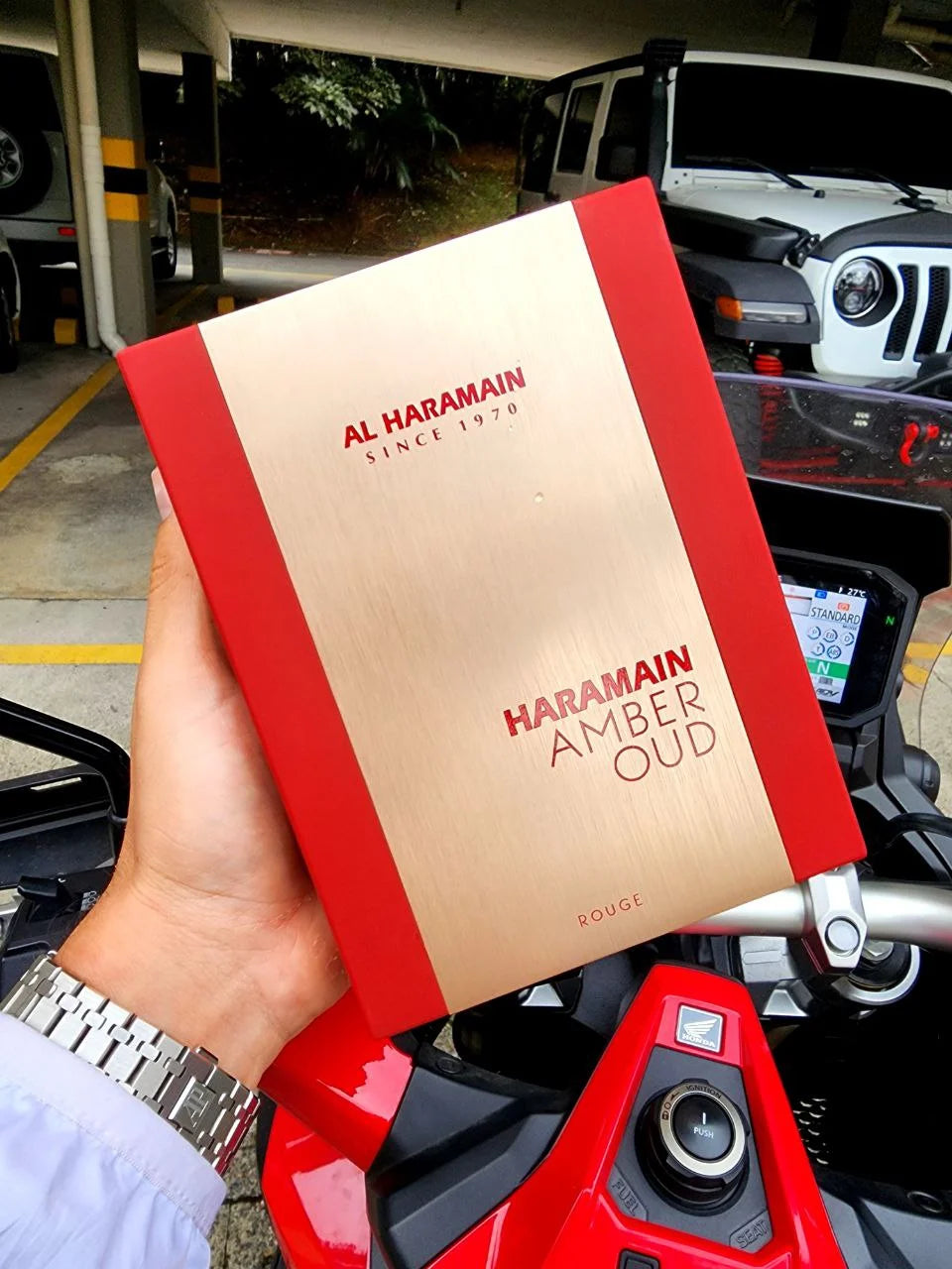 Imagen caja de perfume de fondo una moto y una camioneta